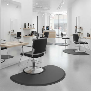 Modern hair salon interior with black chairs and Semi Circle 1" Anti Fatigue Beauty Salon Floor Mat on a white floor.