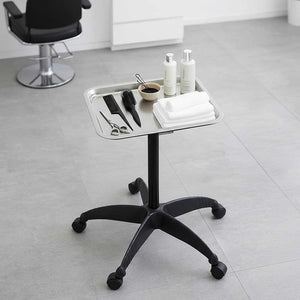 Small round table with grooming tools and products in a salon setting